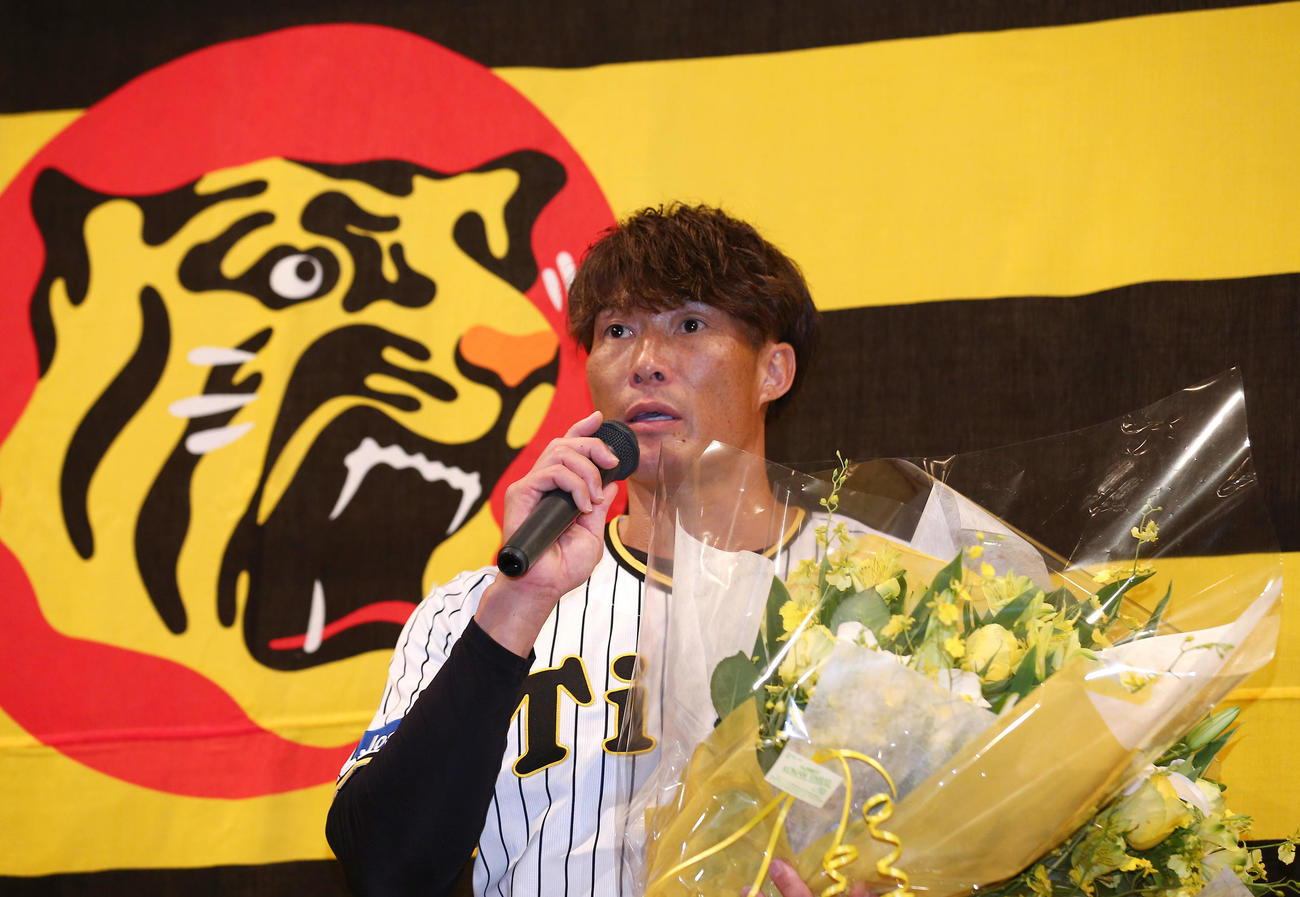 記者会見で花束を手に話す阪神糸井（撮影・上山淳一）