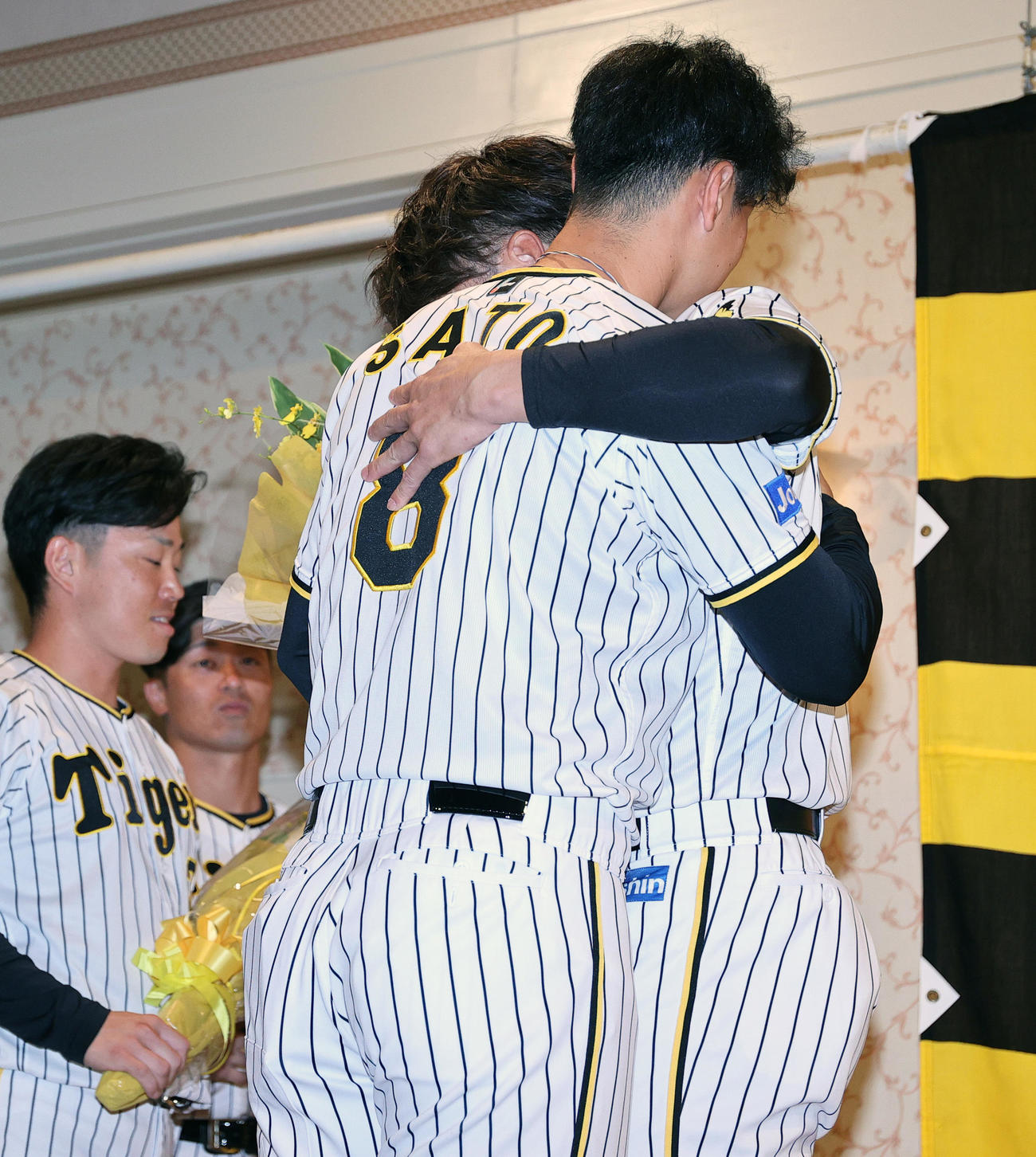 サプライズで登場した阪神佐藤輝（左から3人目）と抱き合う阪神糸井（撮影・上山淳一）