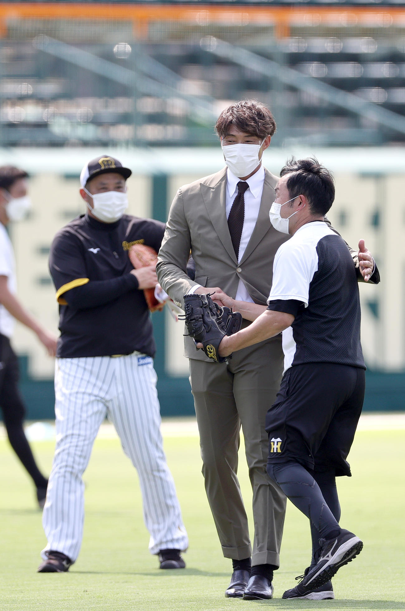 引退会見を終えた阪神糸井（左から3人目）はスーツ姿で甲子園球場に現れ関係者にあいさつする（撮影・上山淳一）