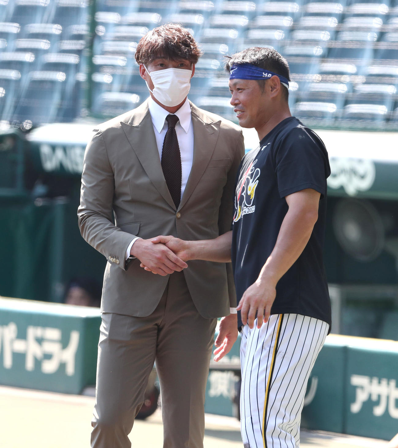 阪神対広島　引退会見を終えた糸井（左）はスーツ姿でグラウンドに現れ原口と握手を交わす（撮影・白石智彦）