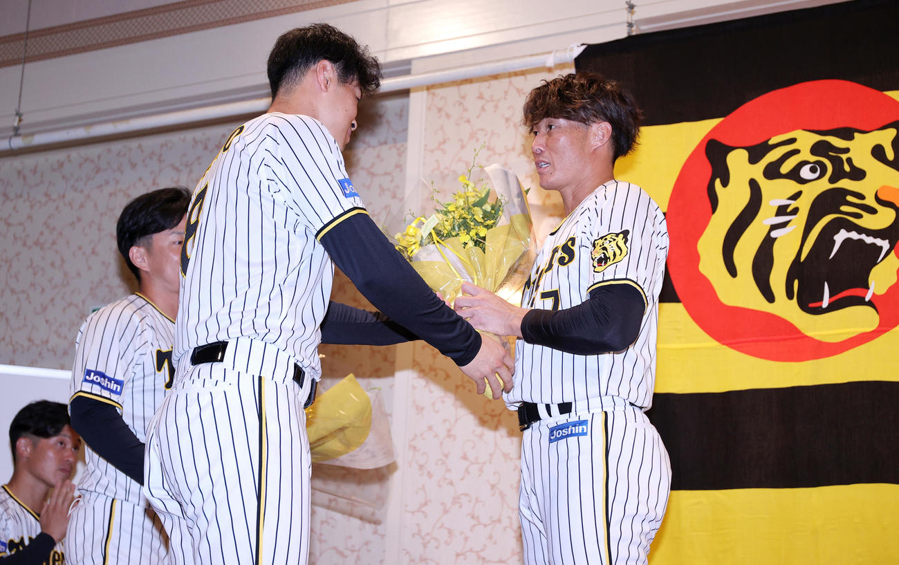 サプライズで登場し、阪神糸井（右）に花束を渡す佐藤輝（左から3人目）、左は坂本、左から2人目は糸原（撮影・上山淳一）