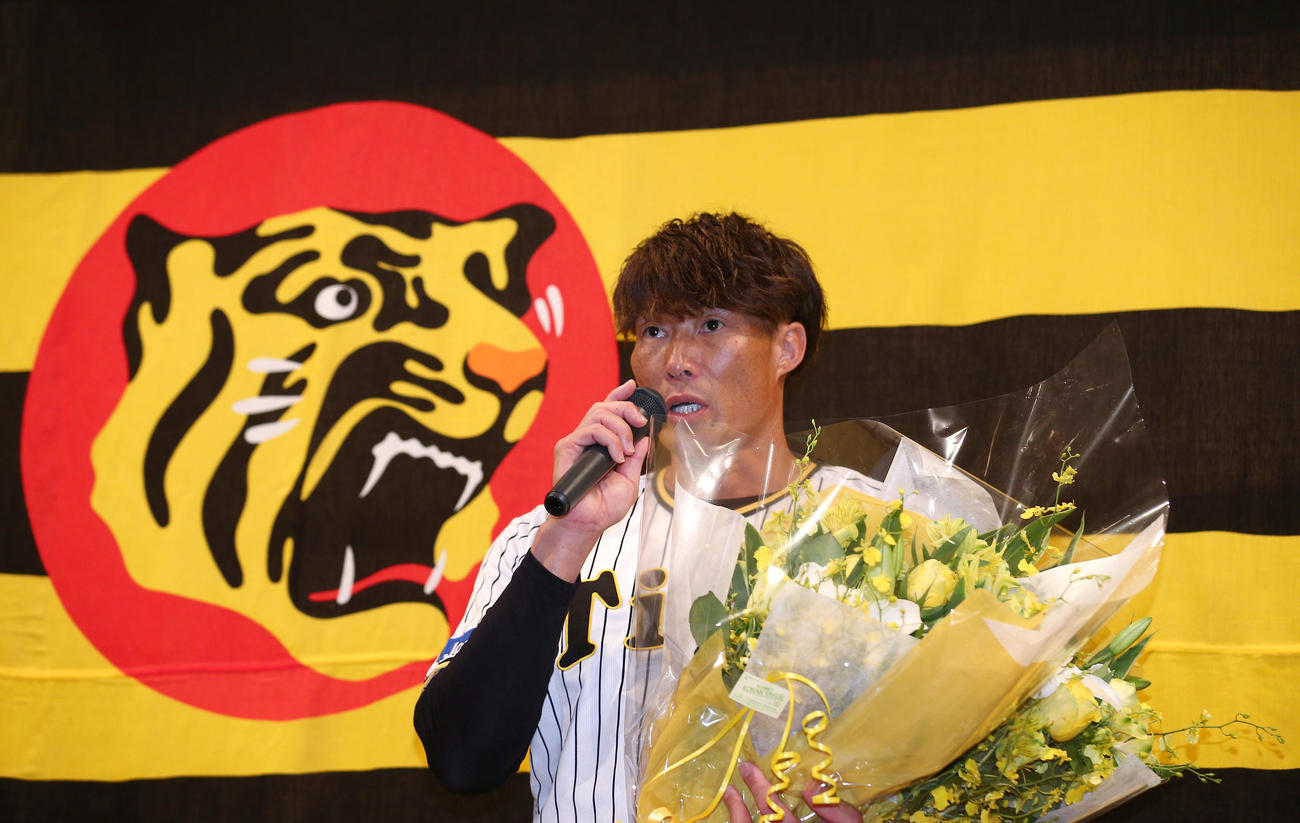 記者会見で花束を手に話す阪神糸井（撮影・上山淳一）