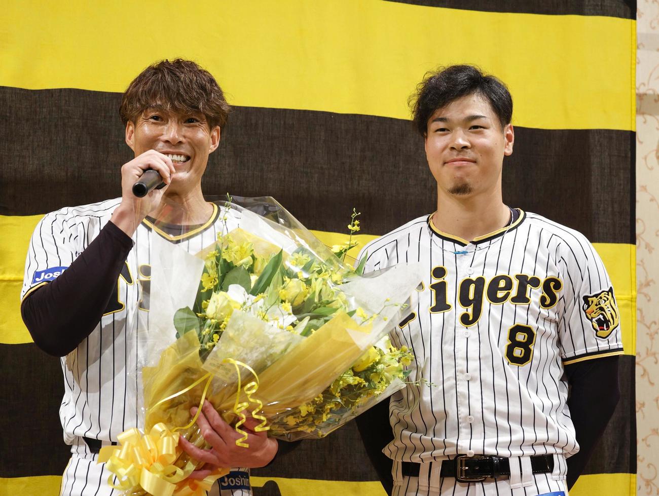 記者会見で、今季限りでの現役引退を表明した阪神の糸井嘉男。右は佐藤輝明（共同）