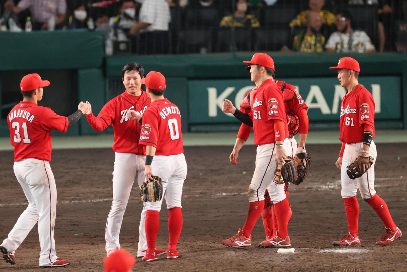 阪神対広島　試合を締めた広島栗林（左から2人目）はナインとタッチを交わす（撮影・上山淳一）