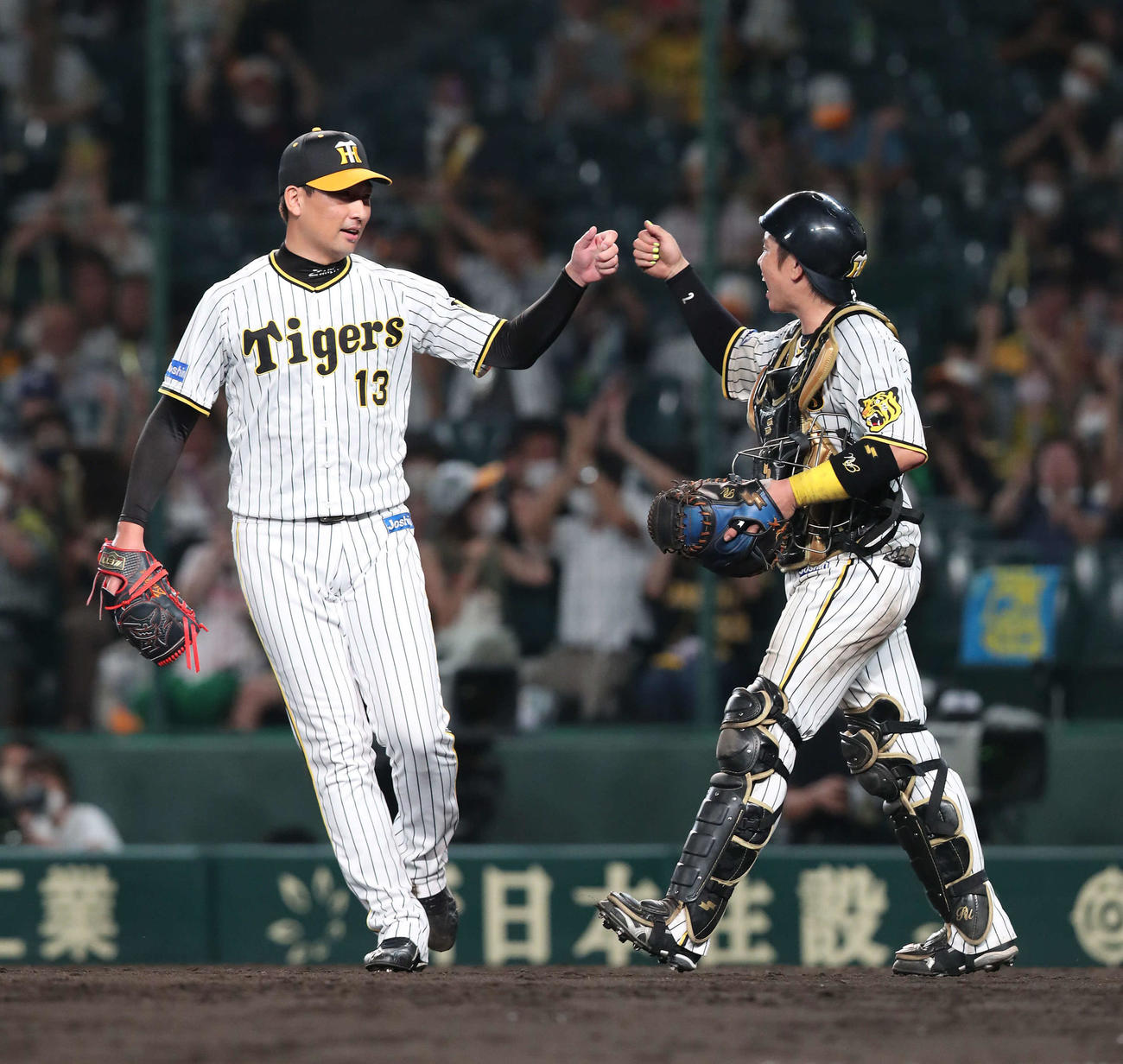 阪神対広島　広島に勝利してグータッチを交わす岩崎（左）と捕手梅野（撮影・白石智彦）