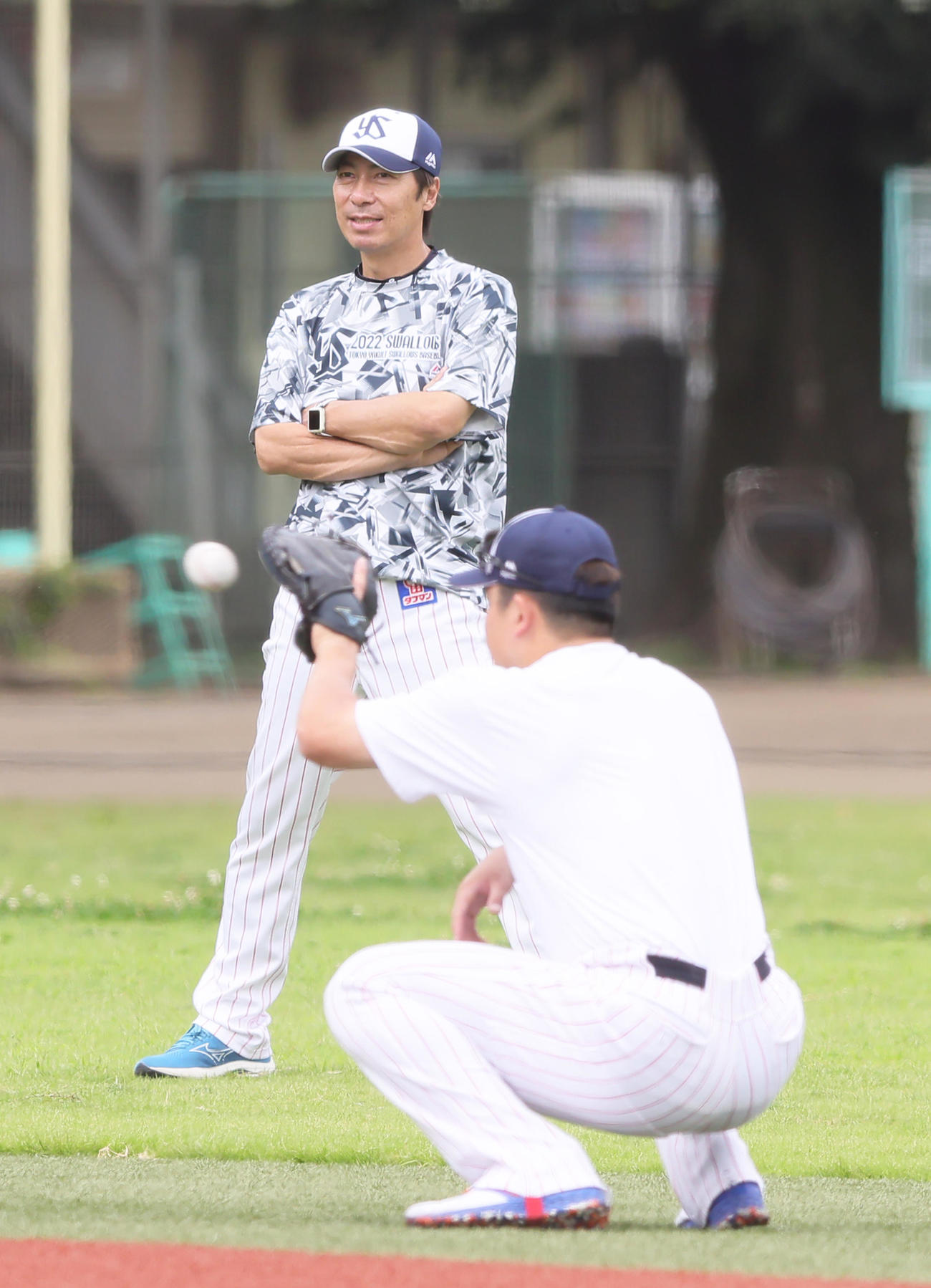 ヤクルト村上（手前）は嶋のミットを手に練習する。後方は高津監督（撮影・足立雅史）