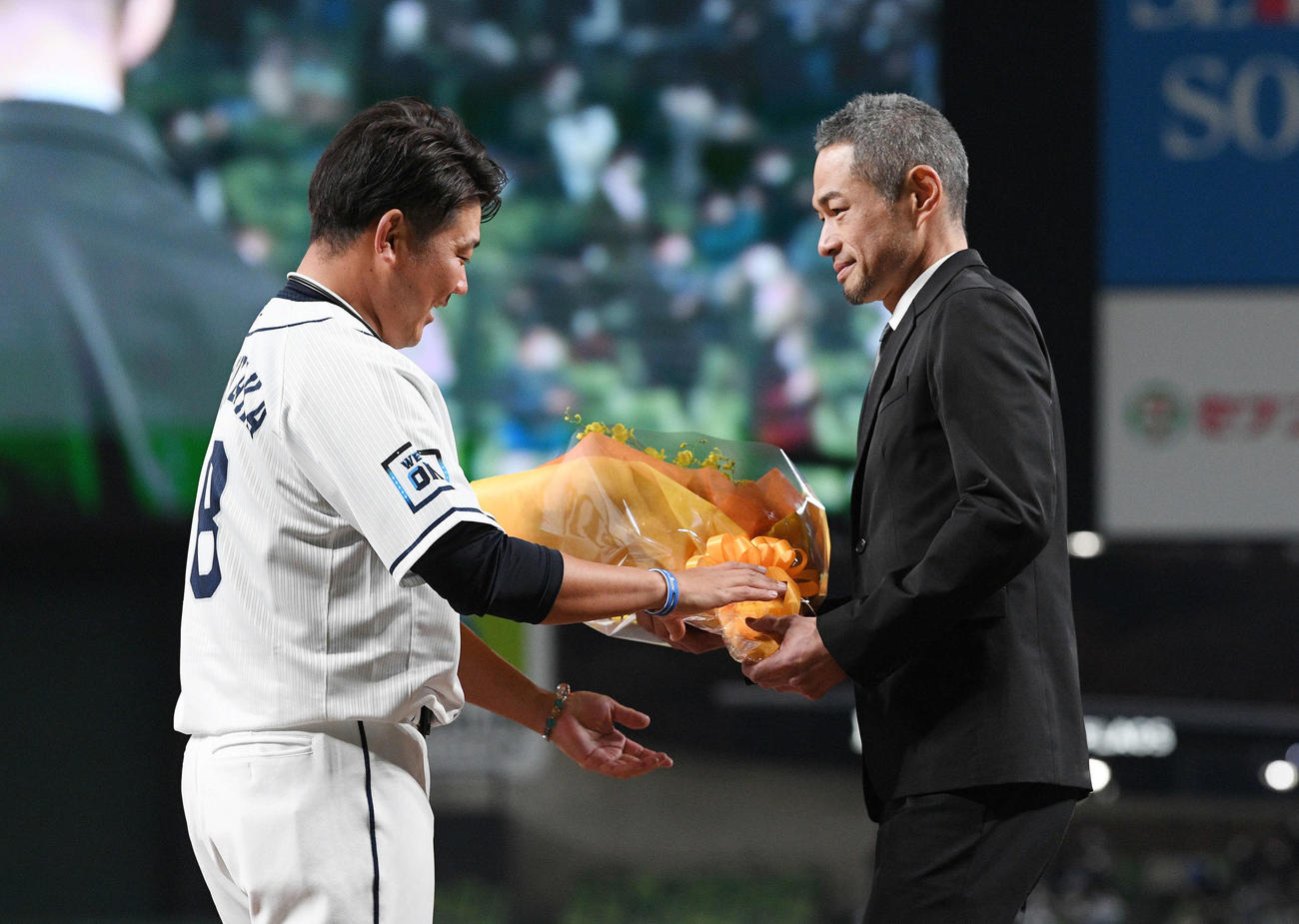 西武松坂（左）は引退セレモニーでサプライズ登場したイチロー氏から花束を受け取る（2021年12月4日撮影）