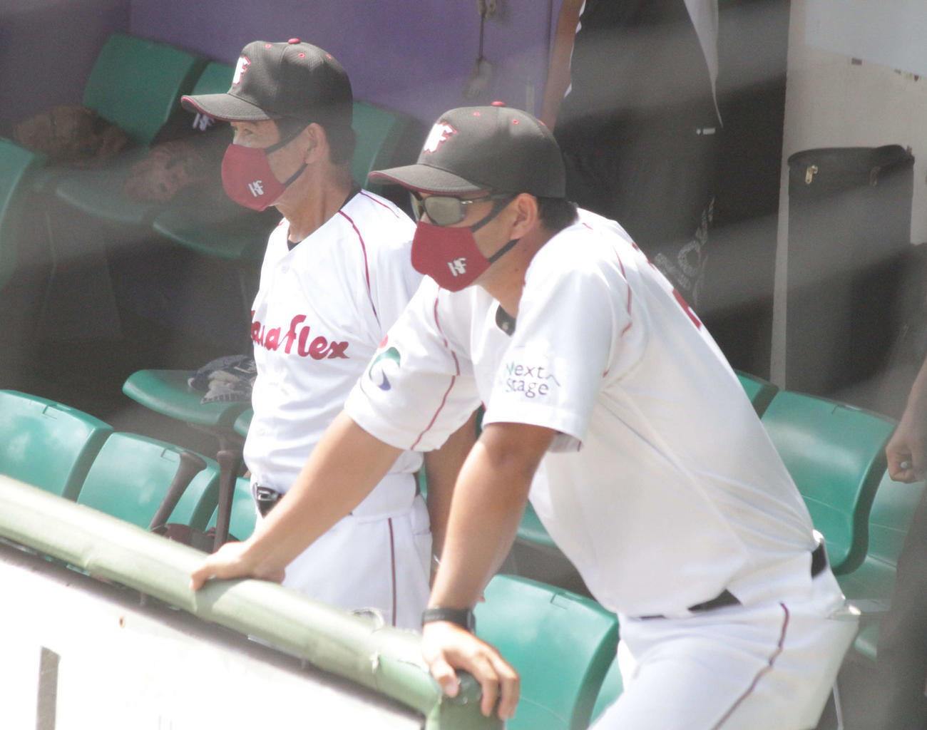 ともに阪神OBのカナフレックス福間納監督（左）と藤井宏政助監督はベンチから試合を見守った