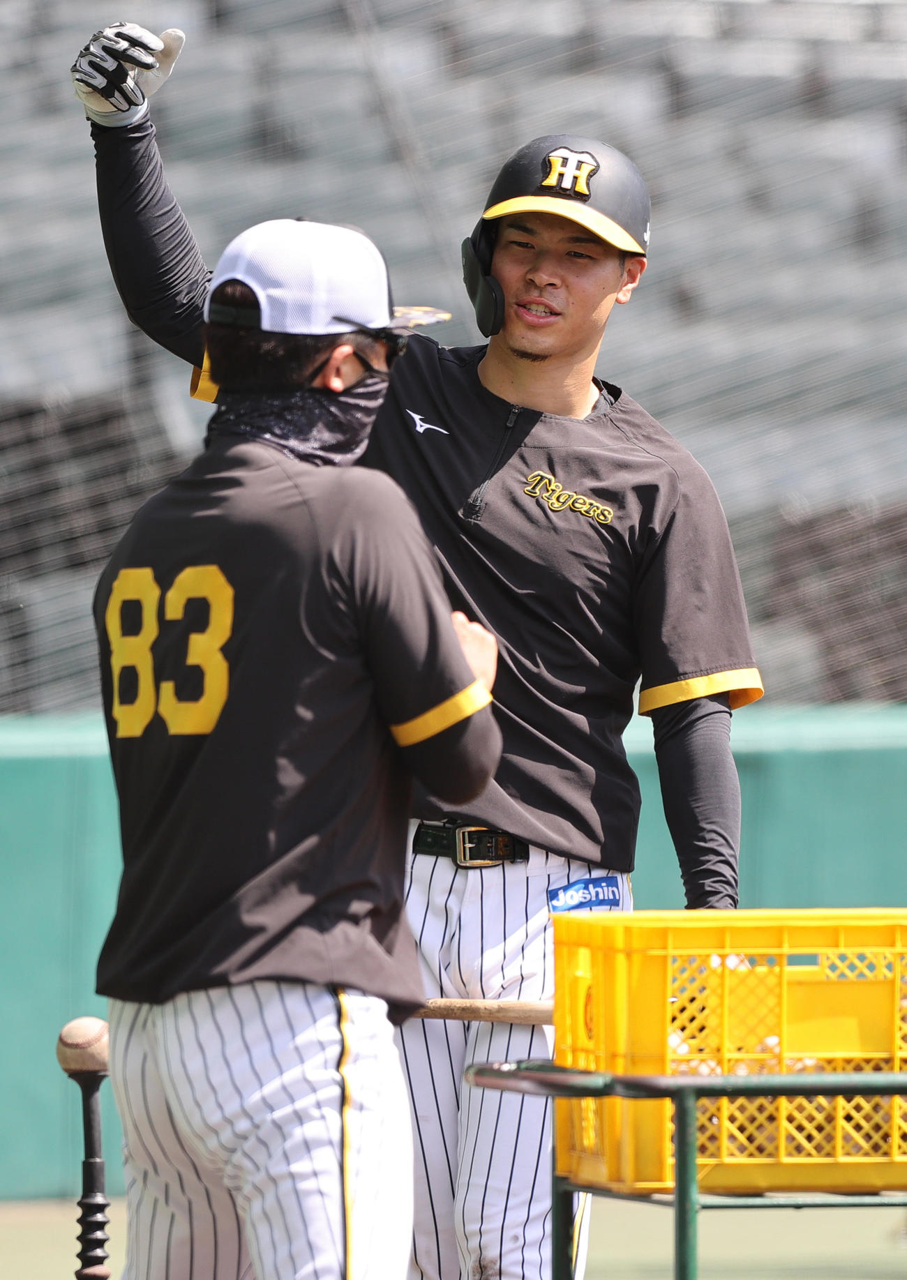 トス打撃の合間に新井打撃コーチ（左）と話す佐藤輝（撮影・上山淳一）