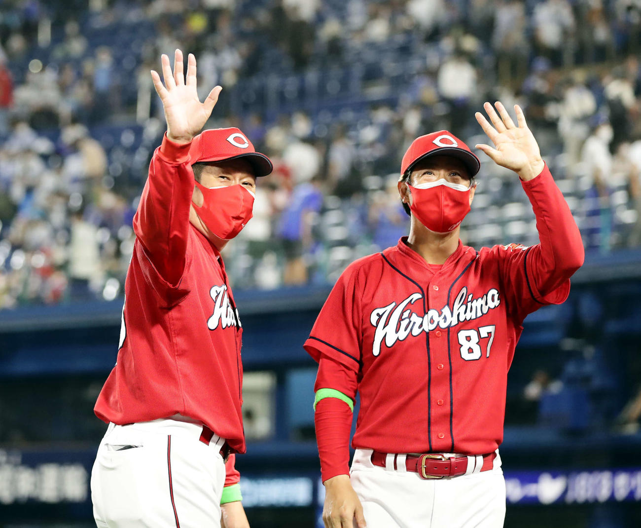 DeNA対広島　勝利し、スタンドに笑顔で手を振る広島佐々岡監督（左）と高橋コーチ（撮影・浅見桂子）