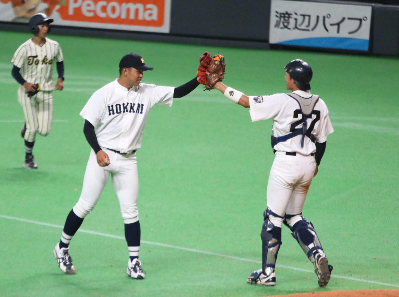 東海大北海道対北海学園大　勝利を決め、北海学園大・堀川（左）は久保田捕手とグラブでタッチする（撮影・山崎純一）