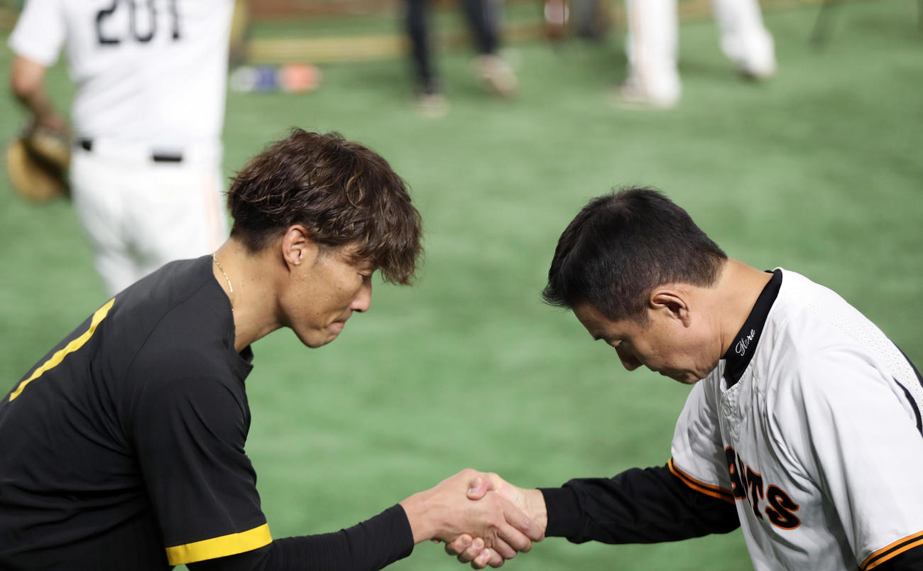巨人対阪神　試合前、原監督（右）に引退のあいさつをし、握手を交わす糸井（撮影・狩俣裕三）