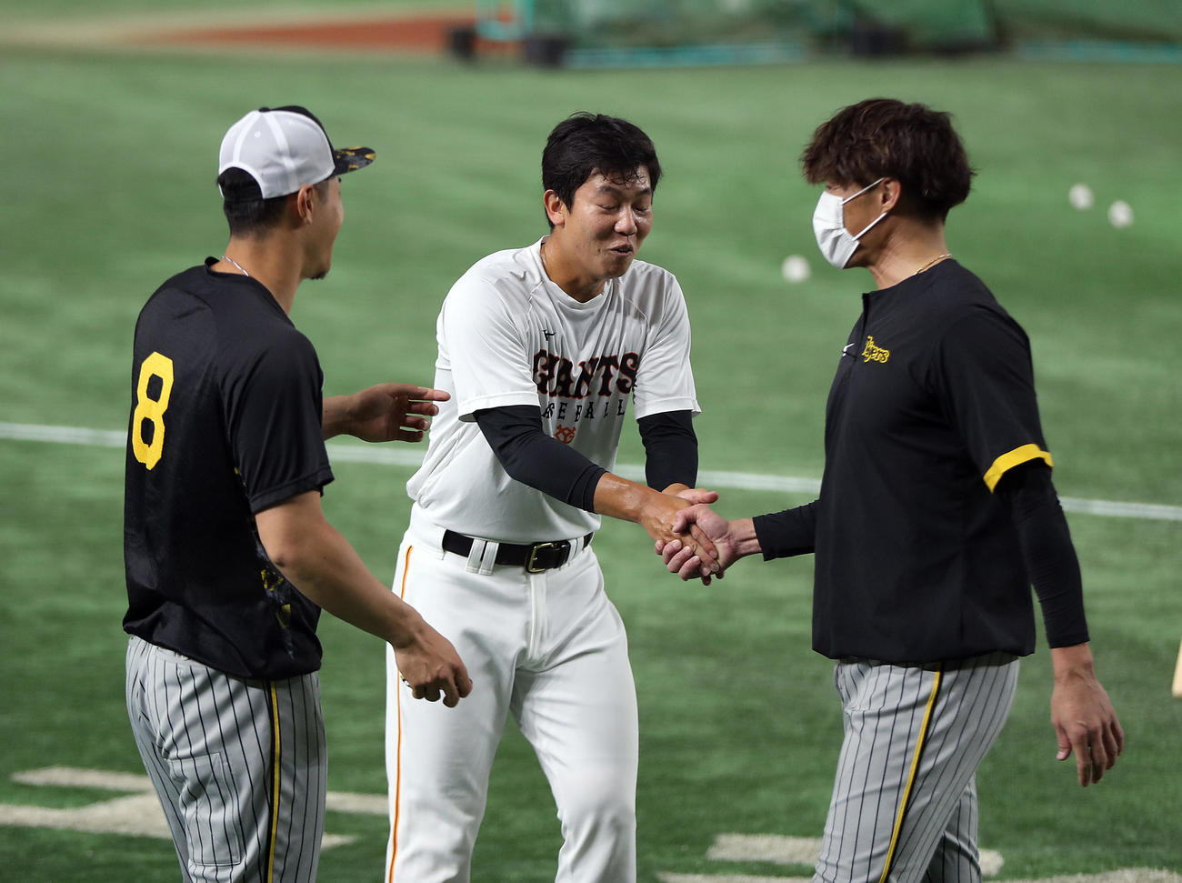巨人対阪神　試合前、近大の先輩の糸井（右）にあいさつする畠（中央）。左は佐藤輝（撮影・狩俣裕三）