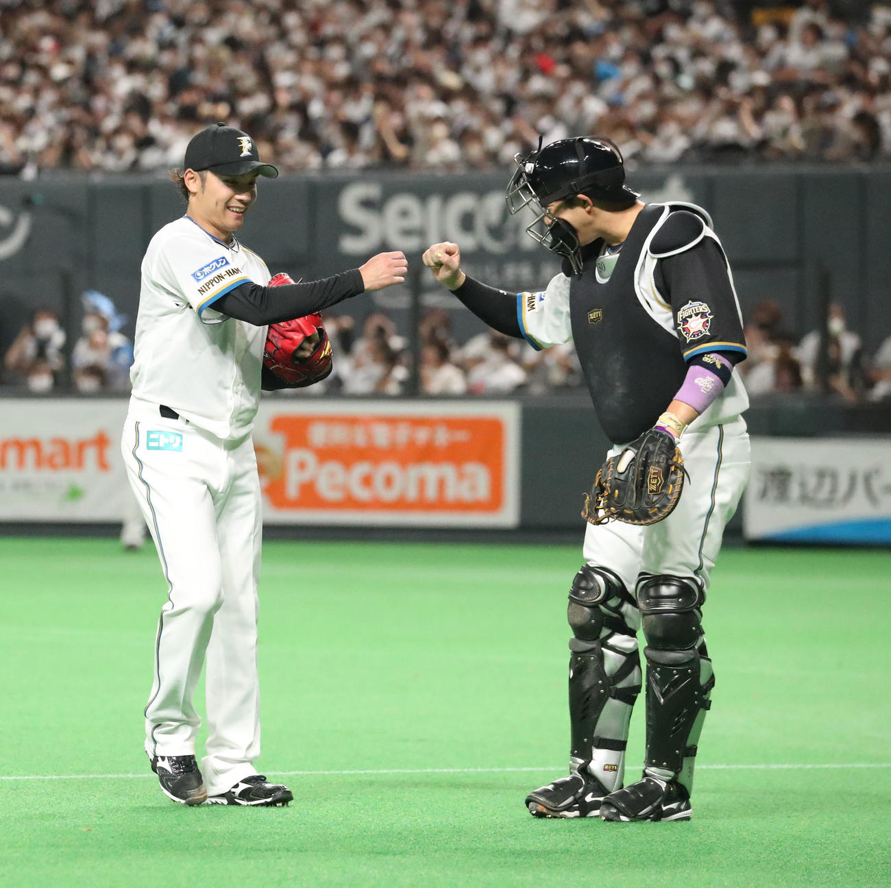 日本ハム対ロッテ　3回表ロッテ2死二、三塁、安田を見逃し三振に仕留めグータッチを交わす伊藤（左）と宇佐見（撮影・佐藤翔太）