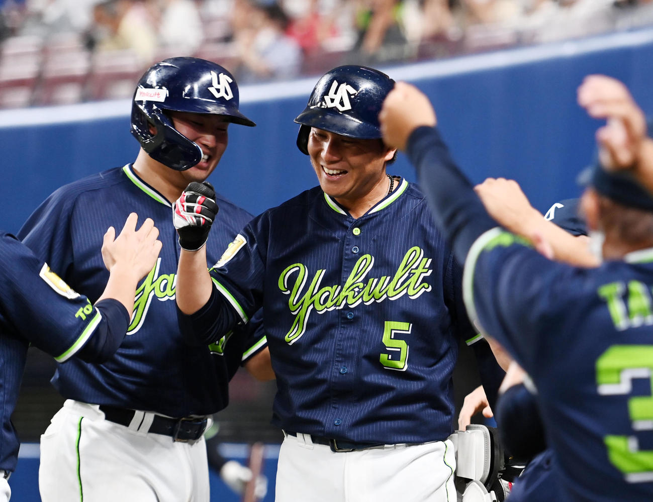 中日対ヤクルト　12回表ヤクルト2死満塁、中前2点適時打を放ちナインとタッチを交わす川端（右）。左は村上（撮影・横山健太）