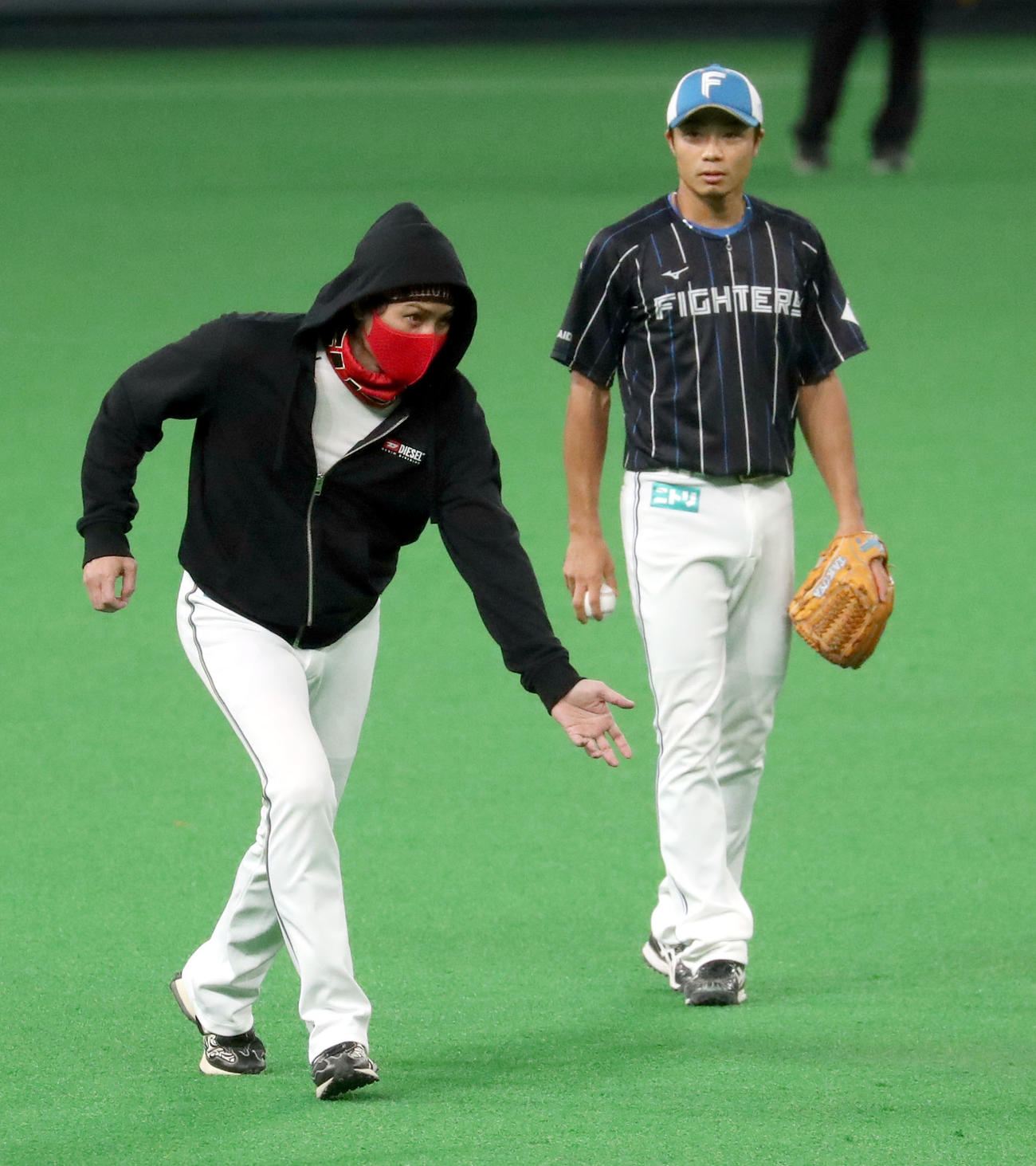 日本ハム対ロッテ　試合前、新庄監督（左手前）は中島に外野守備を指導する（撮影・佐藤翔太）