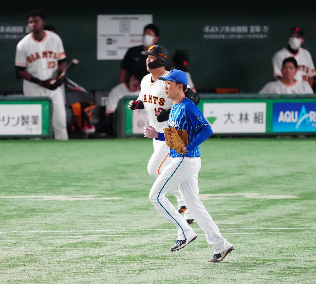巨人対DeNA 4回裏巨人無死、右飛に仕留めた中田（後方）と並走する大貫（撮影・江口和貴）