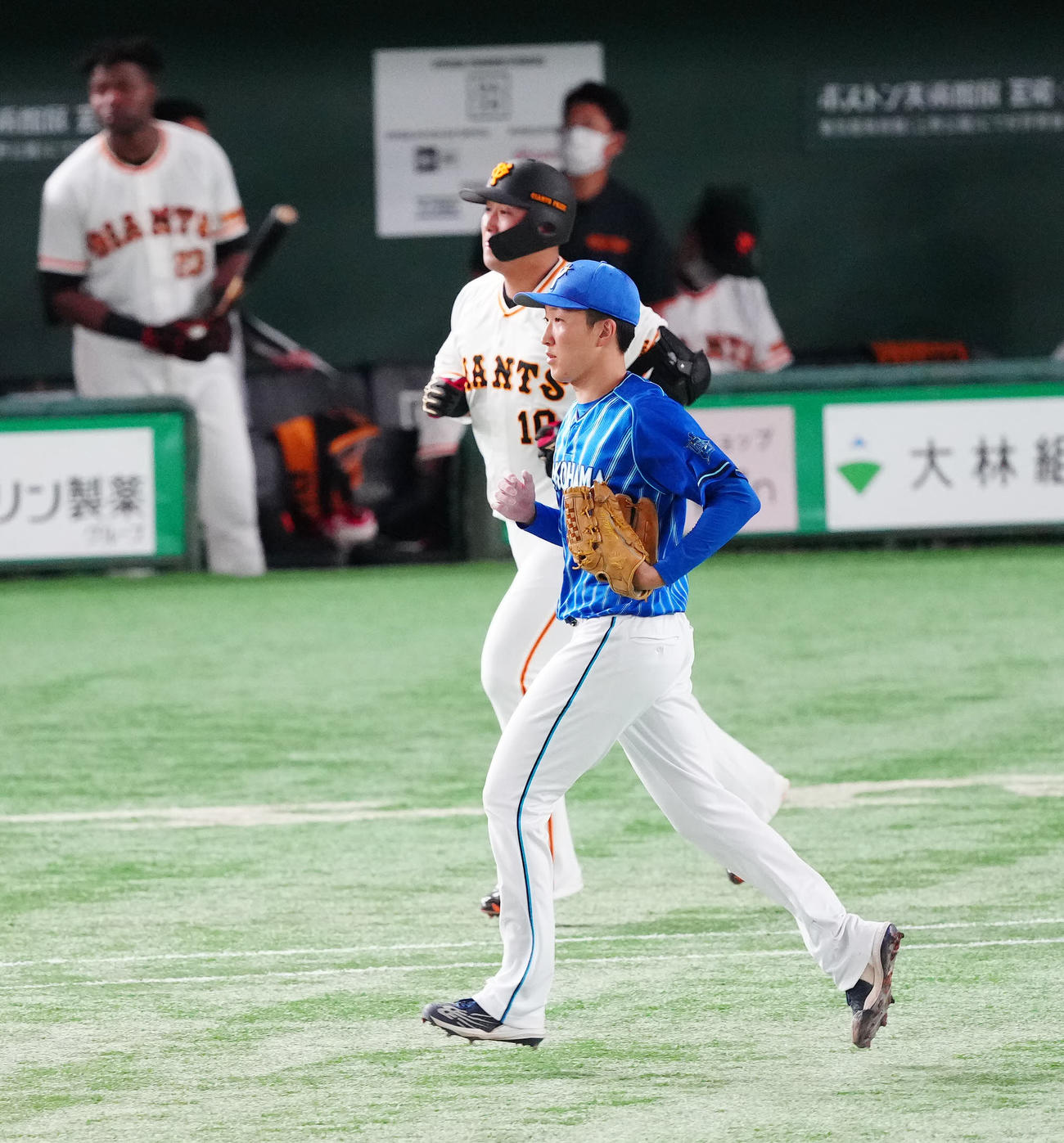 巨人対DeNA 4回裏巨人無死、右飛に仕留めた中田（後方）と並走する大貫（撮影・江口和貴）