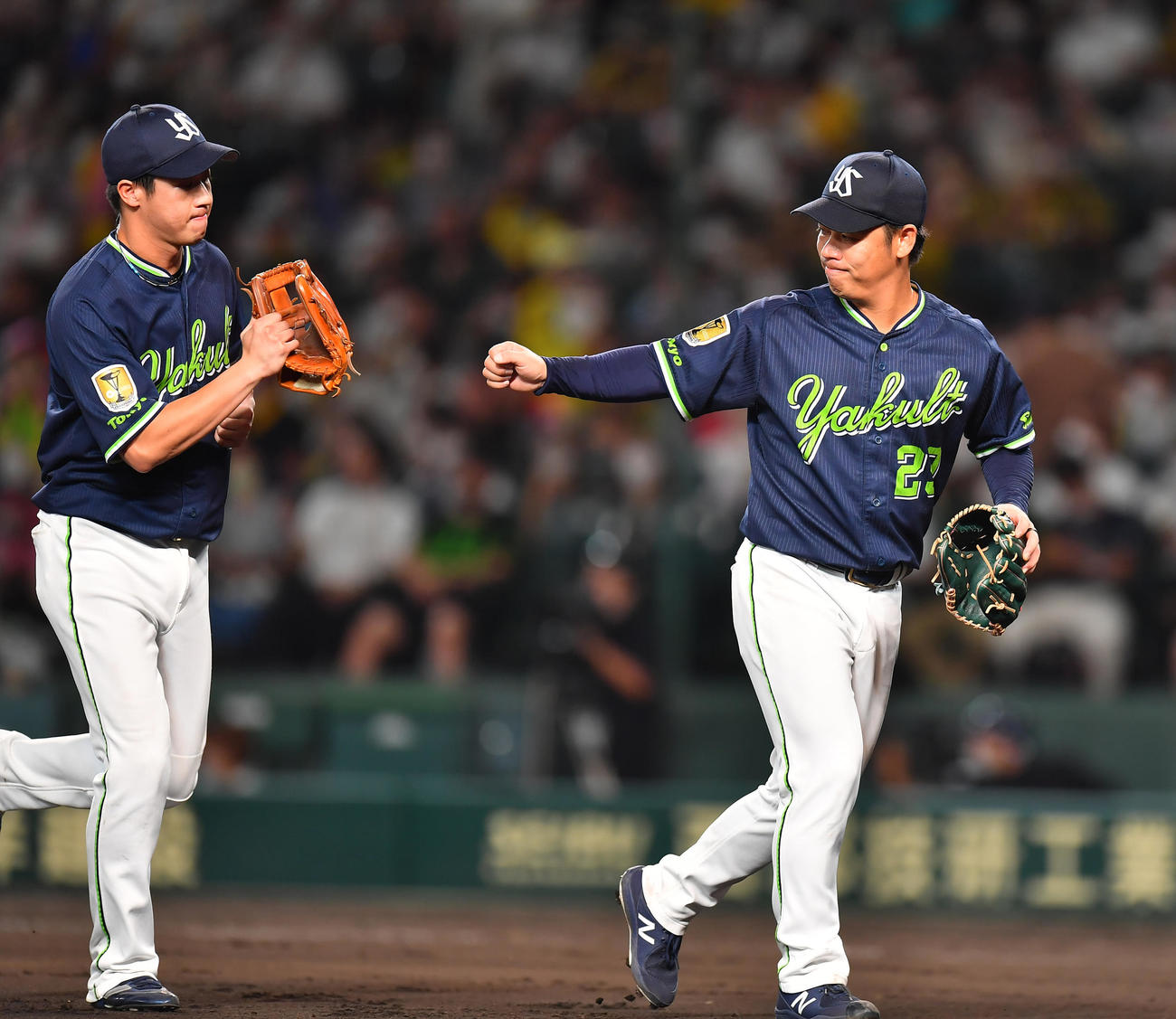 阪神対ヤクルト　6回裏阪神2死二塁、近本を二ゴロに抑え山田（左）とタッチを交わす小川（撮影・清水貴仁）