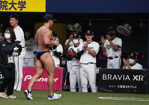 オリックス対ソフトバンク　ユニホームを脱ぎ始球式を行ったボディービルダーの横川尚隆にオリックスの選手も拍手を送る（撮影・清水貴仁）