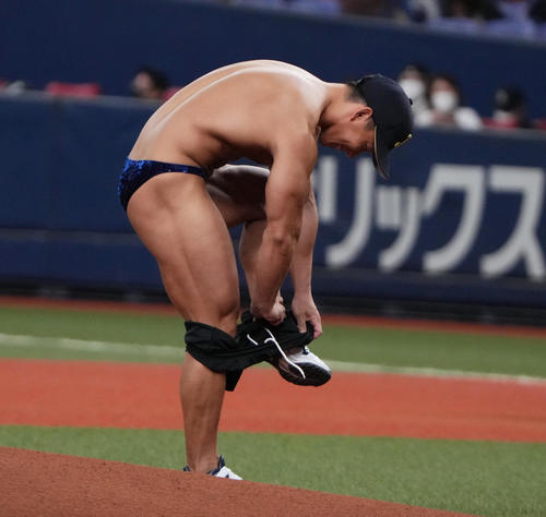 オリックス対ソフトバンク　ユニホームを脱ぎ始球式を行うボディービルダーの横川尚隆（撮影・清水貴仁）