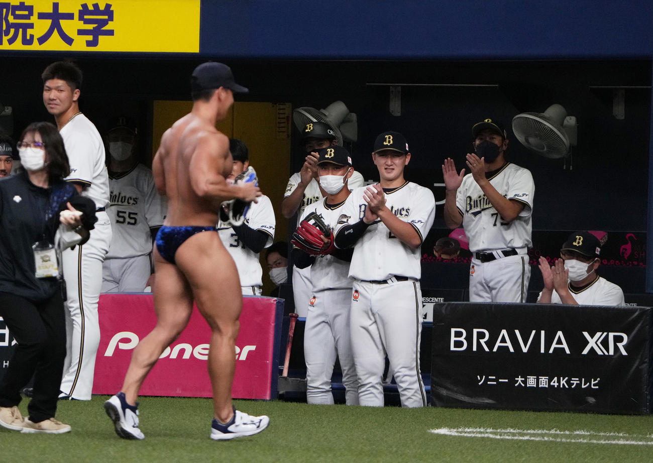 オリックス対ソフトバンク　ユニホームを脱ぎ始球式を行ったボディービルダーの横川尚隆にオリックスの選手も拍手を送る（撮影・清水貴仁）