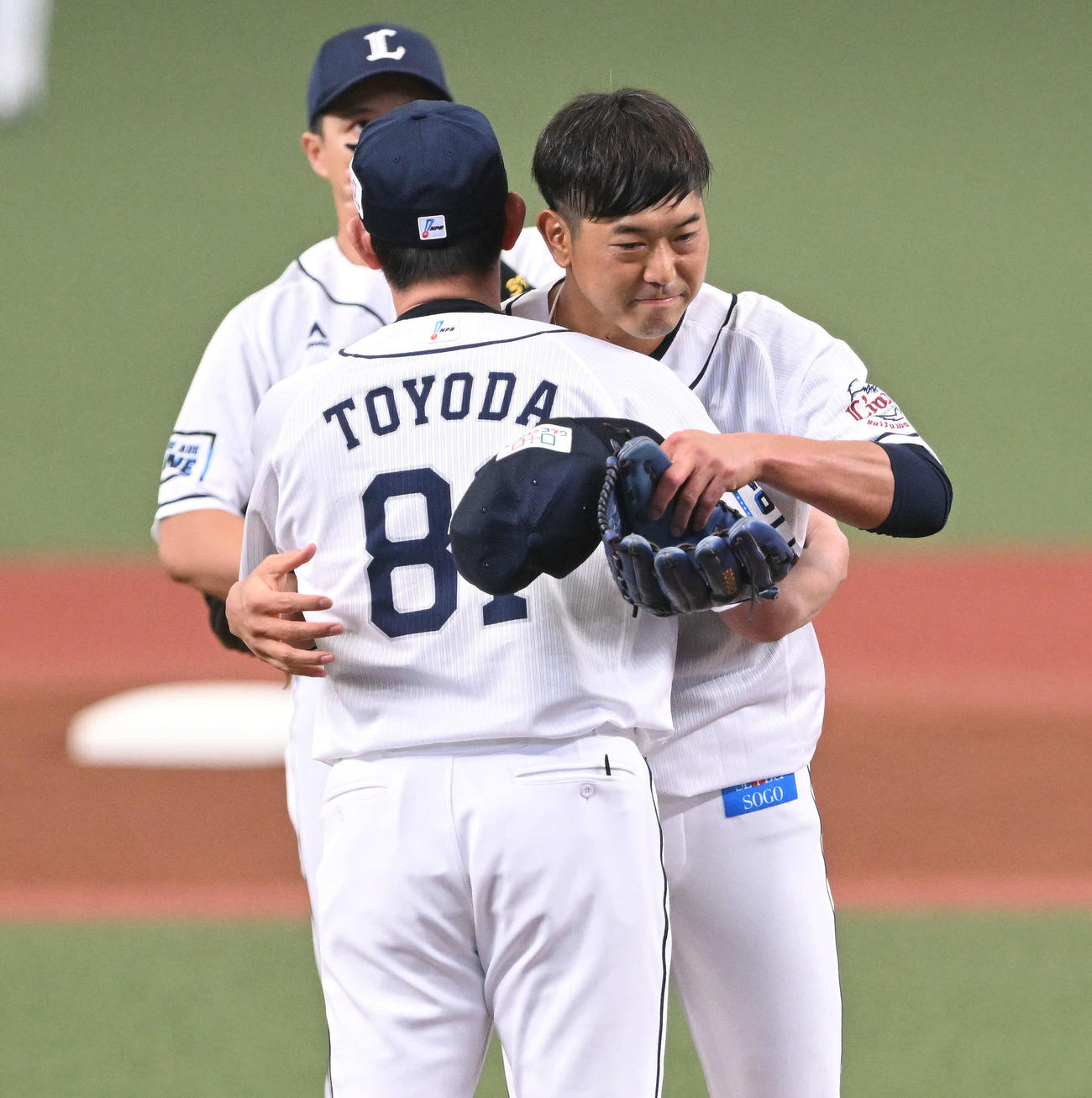 西武対楽天　引退試合の投球を終えた西武内海（手前から2人目）は豊田投手コーチと抱き合う（撮影・滝沢徹郎）