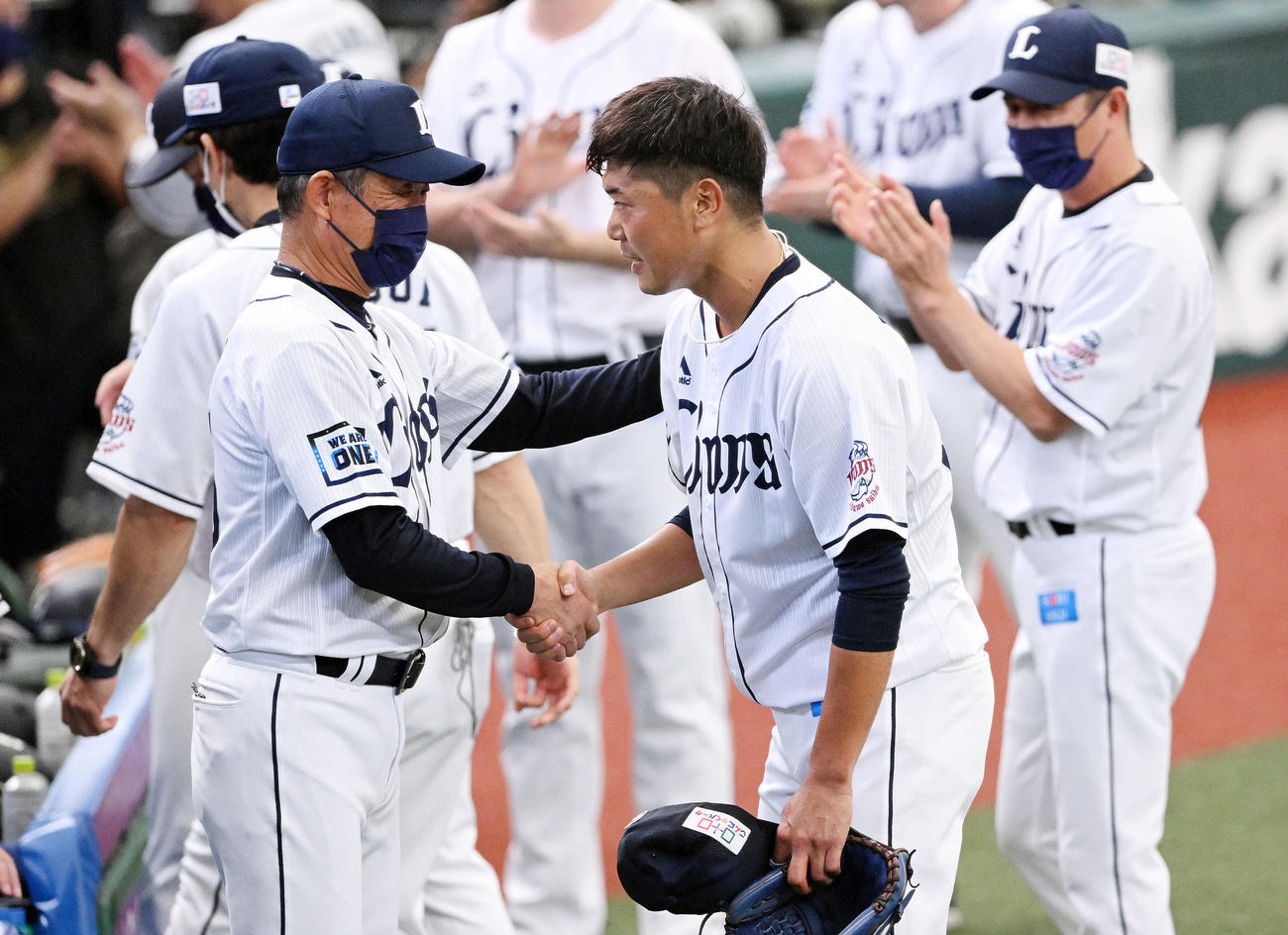 西武対楽天　引退試合での投球を終えた西武内海（手前右）はベンチ前で辻監督と握手を交わす（撮影・滝沢徹郎）
