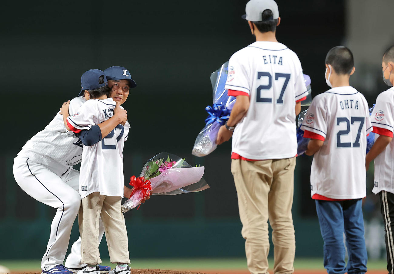 引退セレモニーで子どもたちから花束を贈られ抱擁する西武内海（撮影・浅見桂子）