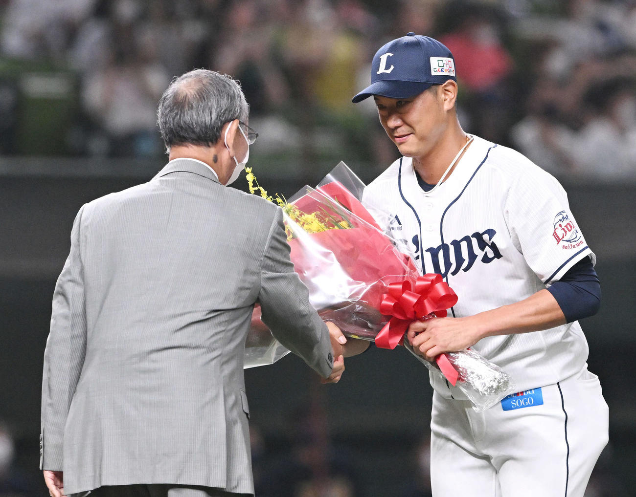 西武対楽天　引退セレモニーで西武内海（右）は堀内恒夫氏から花束を受け取る（撮影・滝沢徹郎）