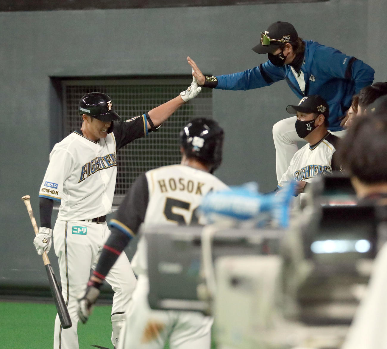 日本ハム対ロッテ　1回裏日本ハム無死一、三塁、中犠飛を放った木村（左）を出迎える新庄監督（撮影・佐藤翔太）