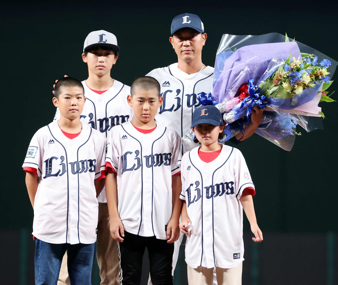 引退セレモニーで子どもたちから花束を贈られ記念撮影する西武内海（撮影・浅見桂子）