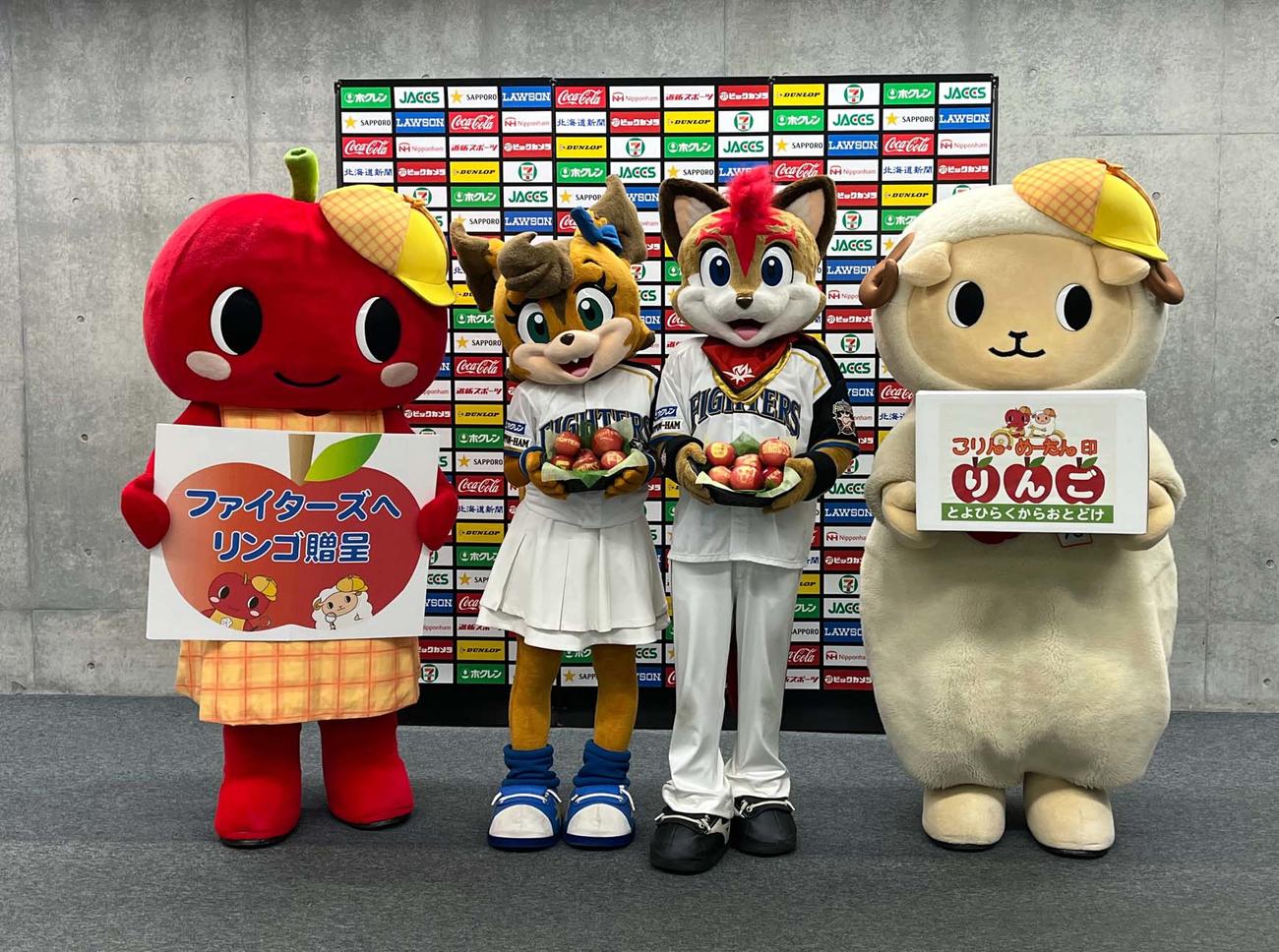 豊平区のキャラクター、こりん（左端）とめーたん（右端）からりんごを贈呈され喜ぶ、日本ハムの球団キャラクター、フレップ（中央右）とポリー（同左）（撮影・永野高輔）