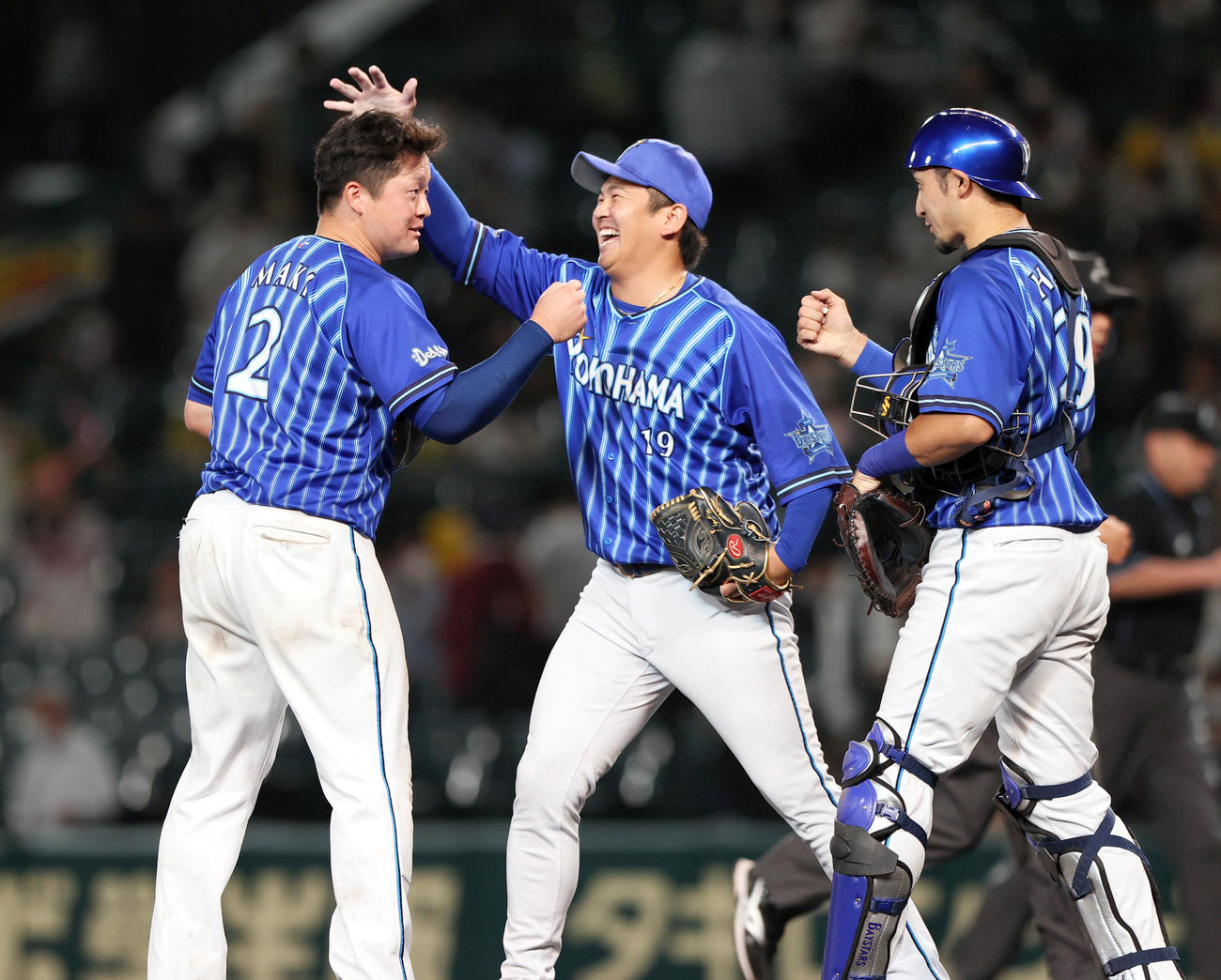 阪神対DeNA　阪神に勝利し、試合を締めたDeNA山崎（中央）は牧の頭を笑顔でなでる。右は伊藤光（撮影・上山淳一）