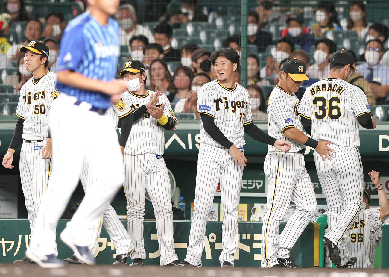 阪神対DeNA 6回表DeNA2死二、三塁、浜地（右）は代打宮崎を空振り三振に仕留めナインの出迎えを受ける（撮影・上山淳一）