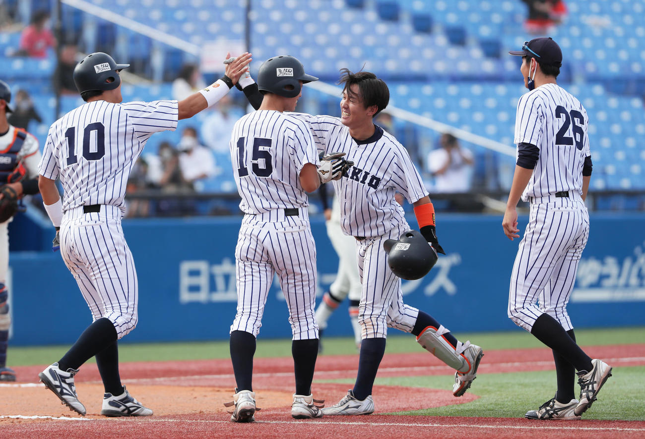 法大対立大　10回裏立大1死満塁、吉岡（中央右）はサヨナラ右前適時打を放ちタッチを交わす（撮影・足立雅史）