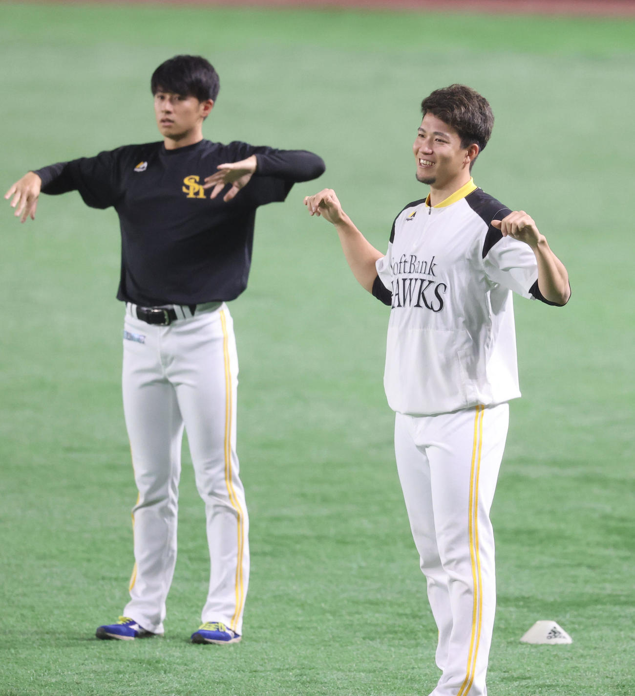 笑顔でストレッチする千賀。左は板東（撮影・梅根麻紀）