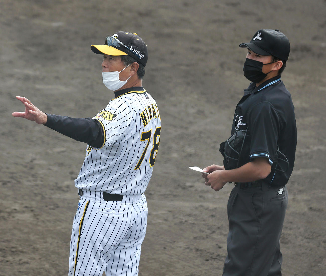 ウエスタン・リーグ阪神対オリックス　阪神秋山拓巳のアクシデントに急きょ主審に交代を告げる阪神平田2軍監督（左）（撮影・上山淳一）