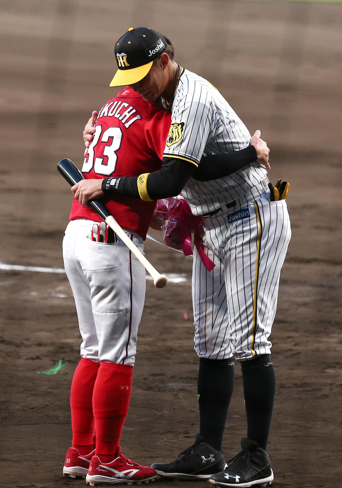 阪神対広島　糸井嘉男（右）は広島菊池涼から花束を贈られ抱擁する（撮影・上山淳一）