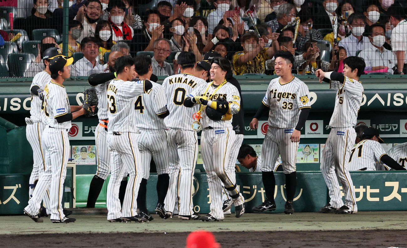 阪神対広島　6回裏阪神2死、左越えソロ本塁打を放った梅野はナインと笑顔でタッチ（撮影・加藤哉）