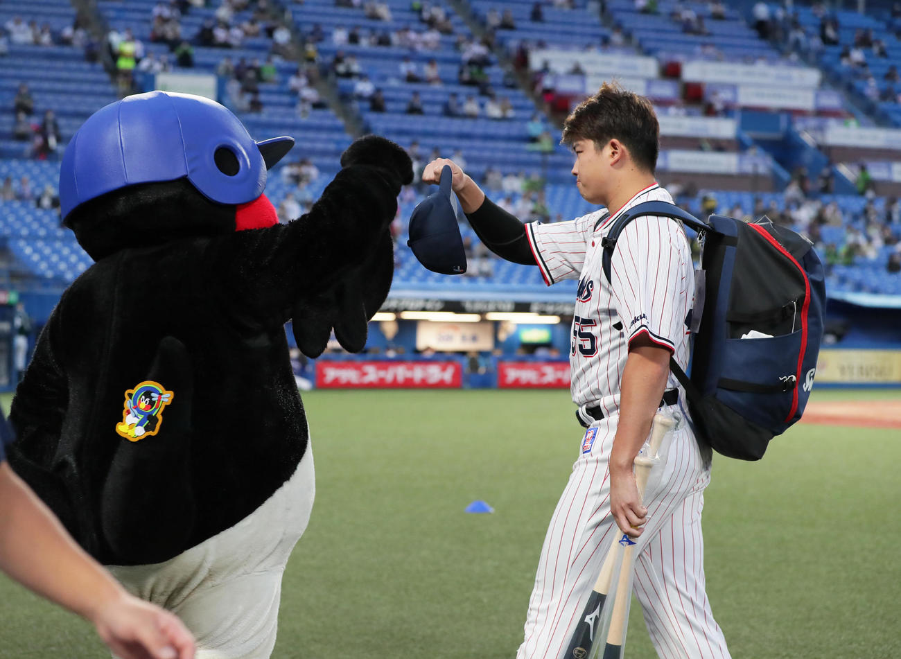 試合前、つば九郎とタッチを交わすヤクルト村上（撮影・足立雅史）
