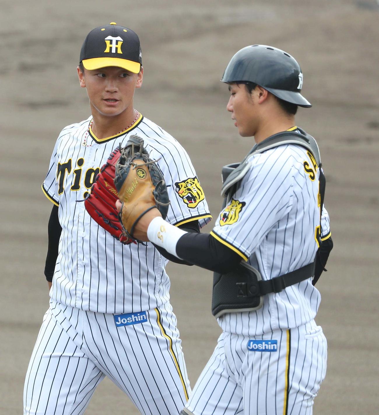 阪神対オリックス　6回表オリックス攻撃終了、森木（左）はオリックス打線を無失点に抑え栄枝とグラブタッチ（撮影・上田博志）