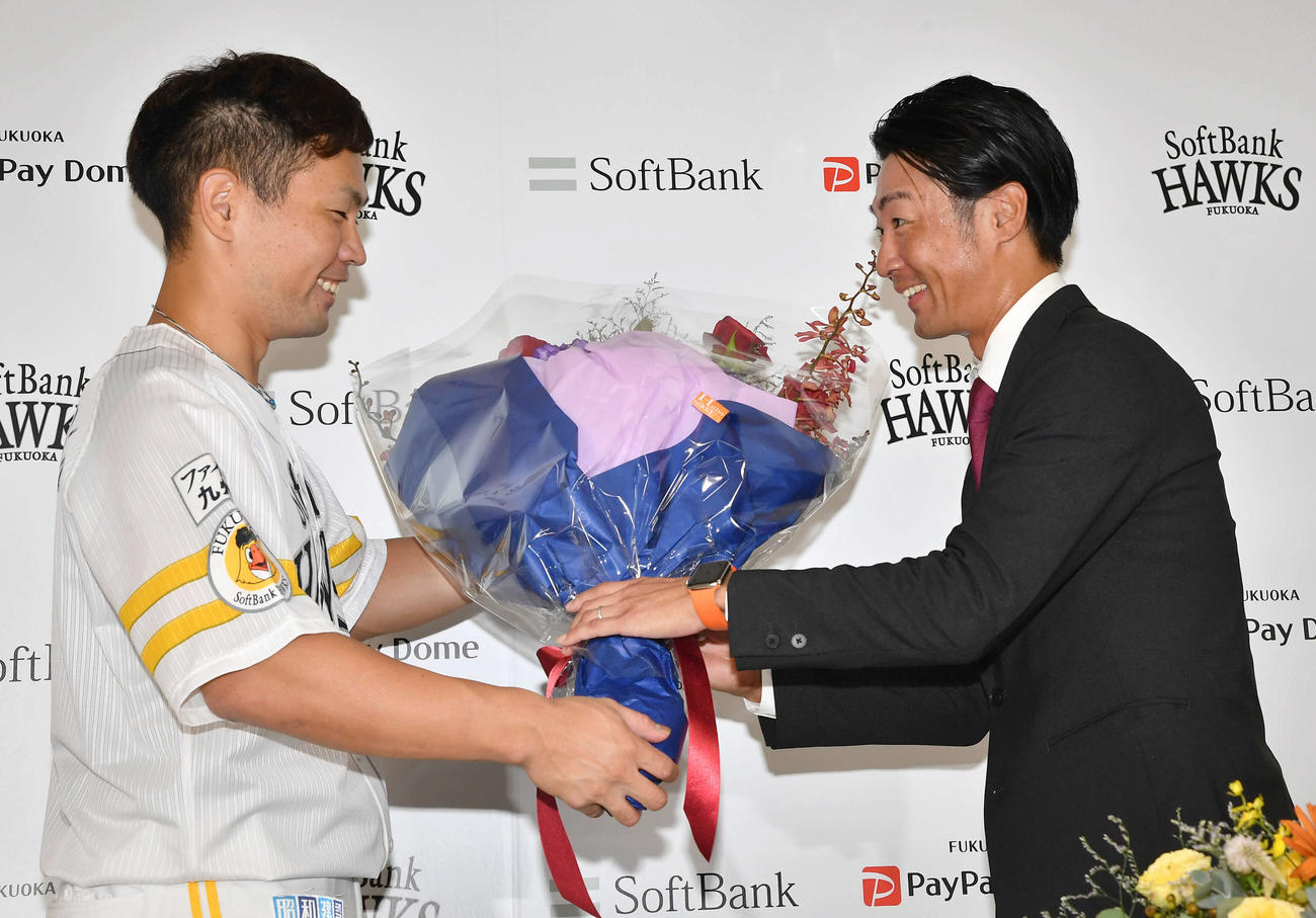引退会見で中村晃（左）から花束を受け取る明石（撮影・岩下翔太）