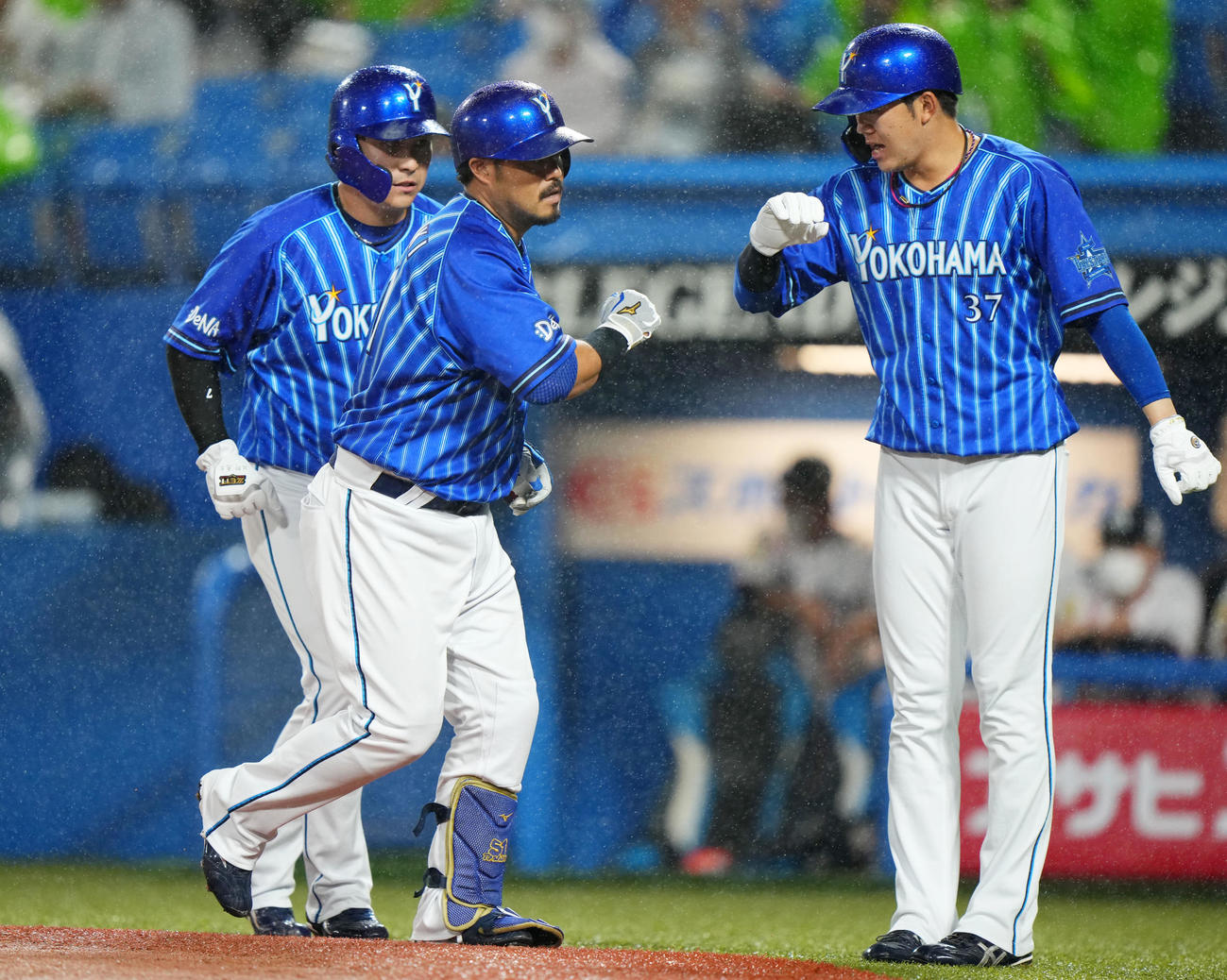 ヤクルト対DeNA 1回表DeNA2死一、二塁、右越え3点本塁打を放ちタッチを交わす宮崎（中央）。左は佐野、右は楠本（撮影・横山健太）