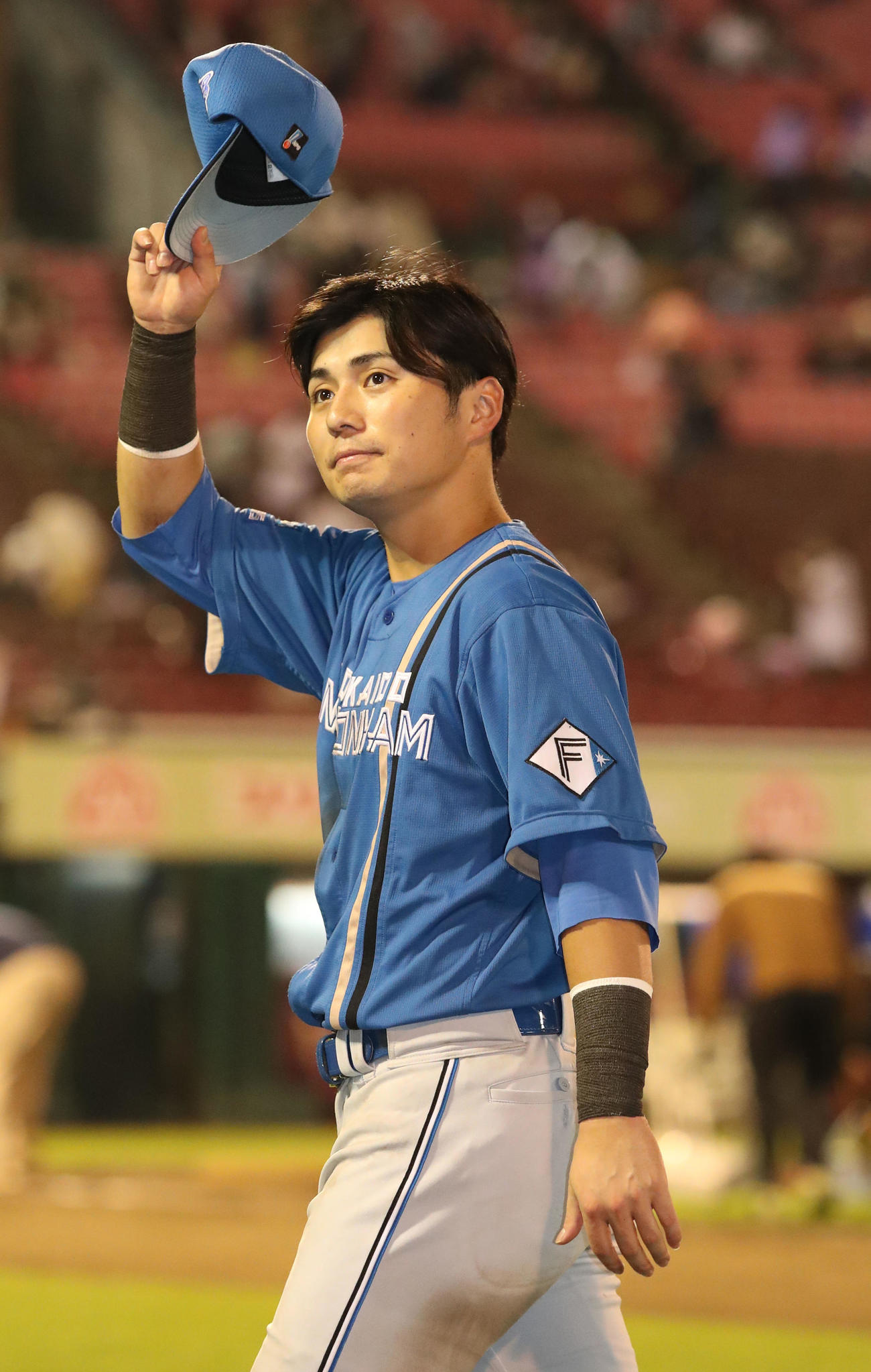 楽天対日本ハム　スタンド応援席のファンに手を振りながら引き揚げる上川畑（撮影・佐藤翔太）