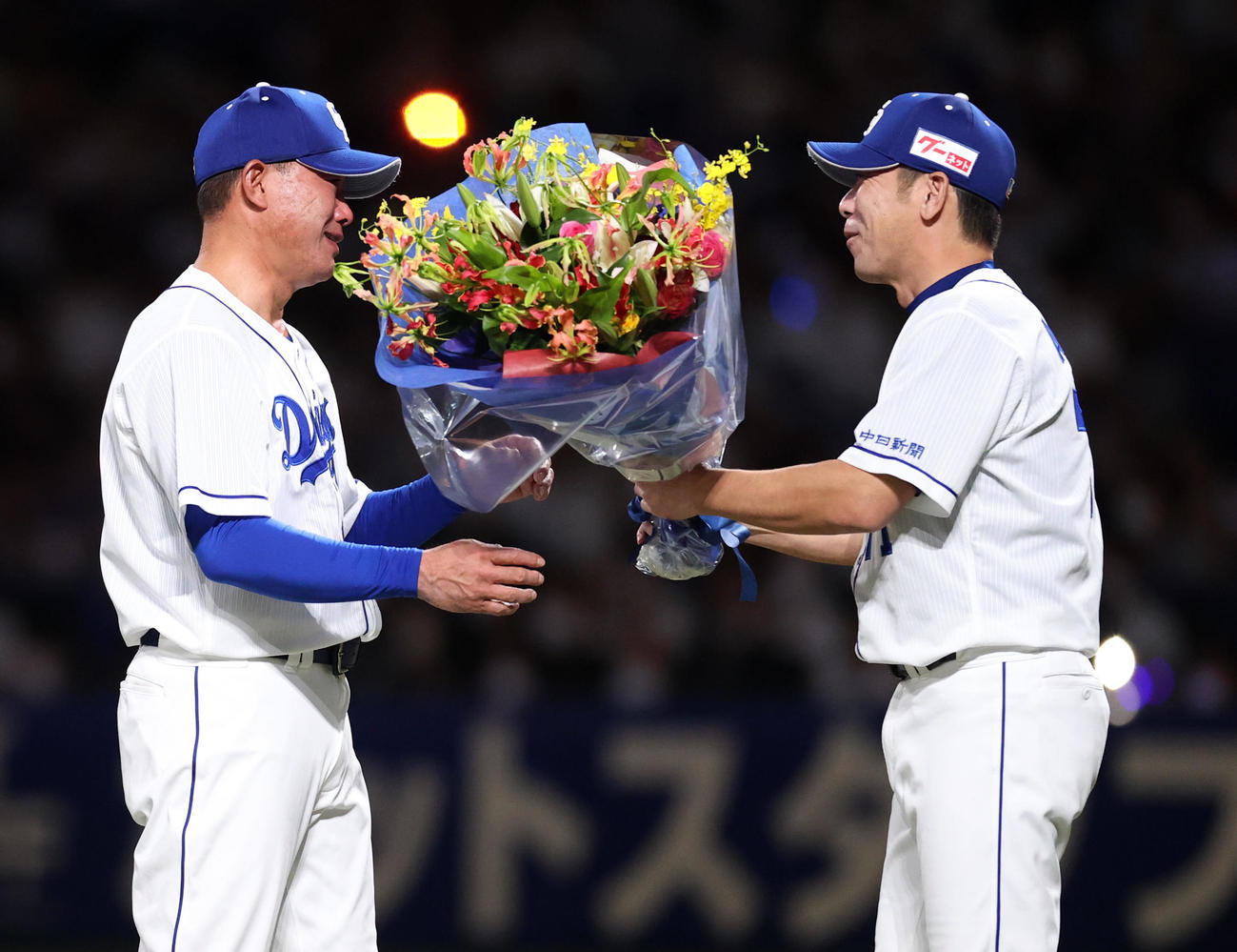 中日対巨人　引退セレモニーで荒木コーチ（右）から花束を受け取り、涙を流す福留（撮影・狩俣裕三）