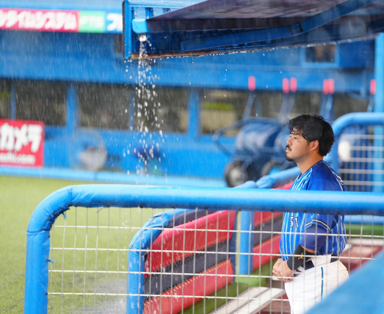 ヤクルト対DeNA　試合前、ベンチから降雨を見つめるDeNA宮崎（撮影・江口和貴）