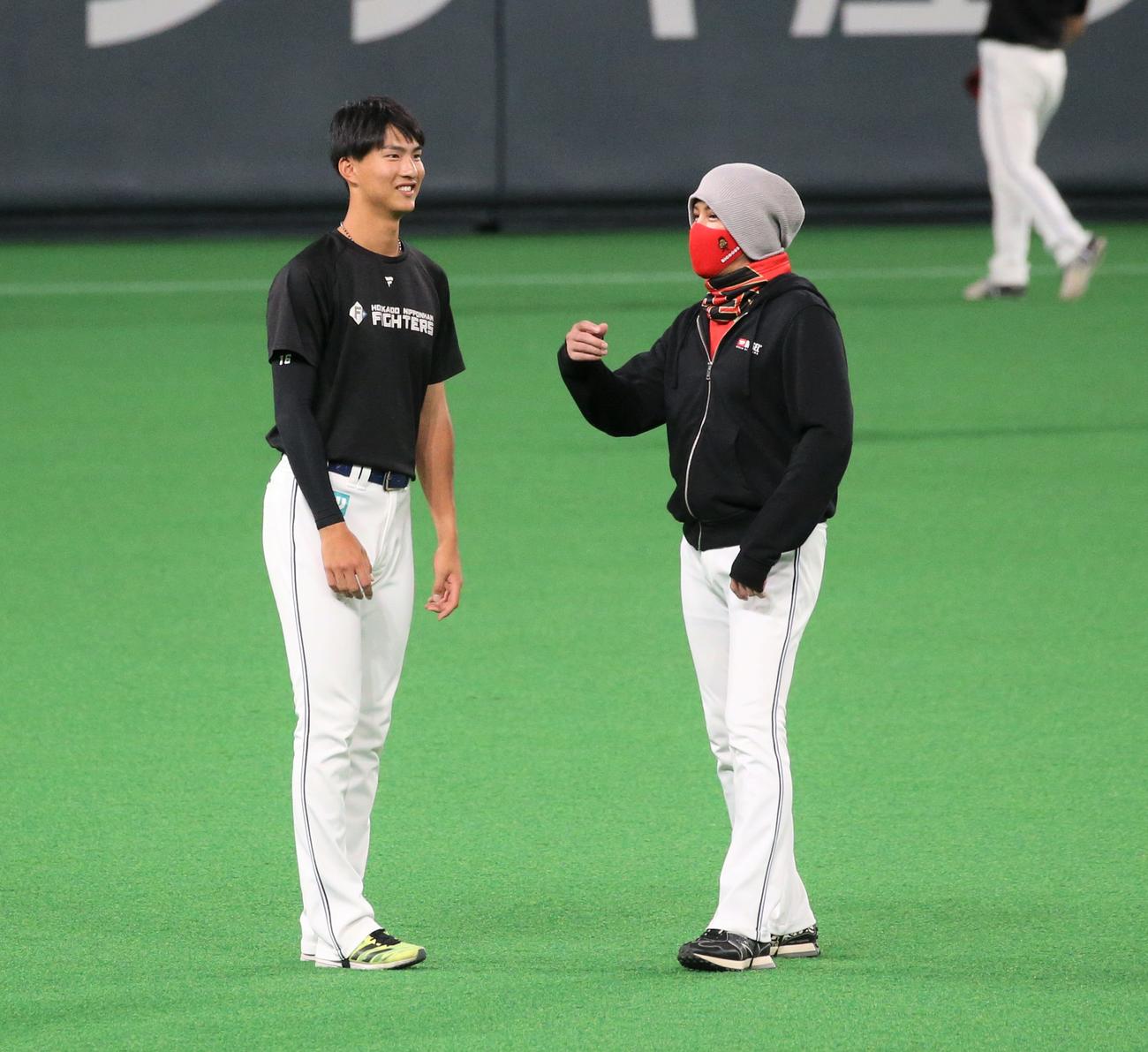 日本ハム対西武　練習中、新庄監督（右）と話す達（撮影・黒川智章）