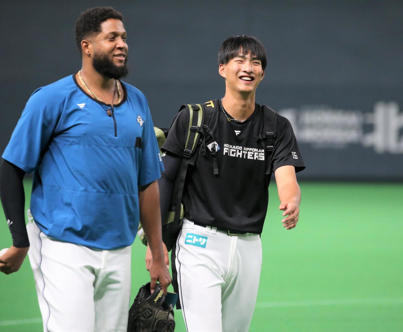 日本ハム対西武　ロドリゲス（左）と笑顔で話す達（撮影・黒川智章）