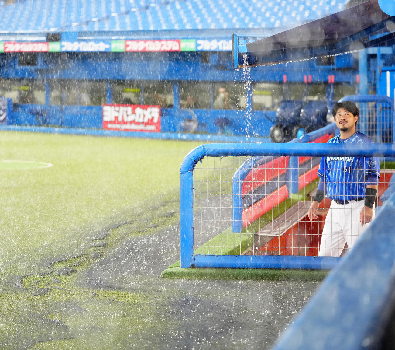 ヤクルト対DeNA　試合前、ベンチから降雨を見つめるDeNA宮崎（撮影・江口和貴）